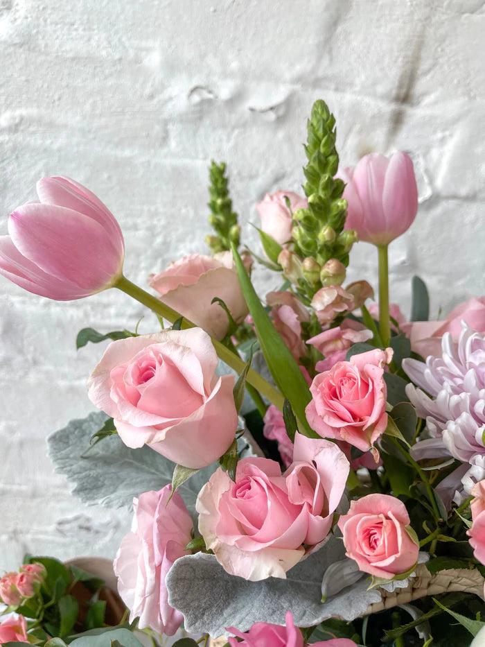 Lucia, cesta con exquisita variedad de flores rosadas.